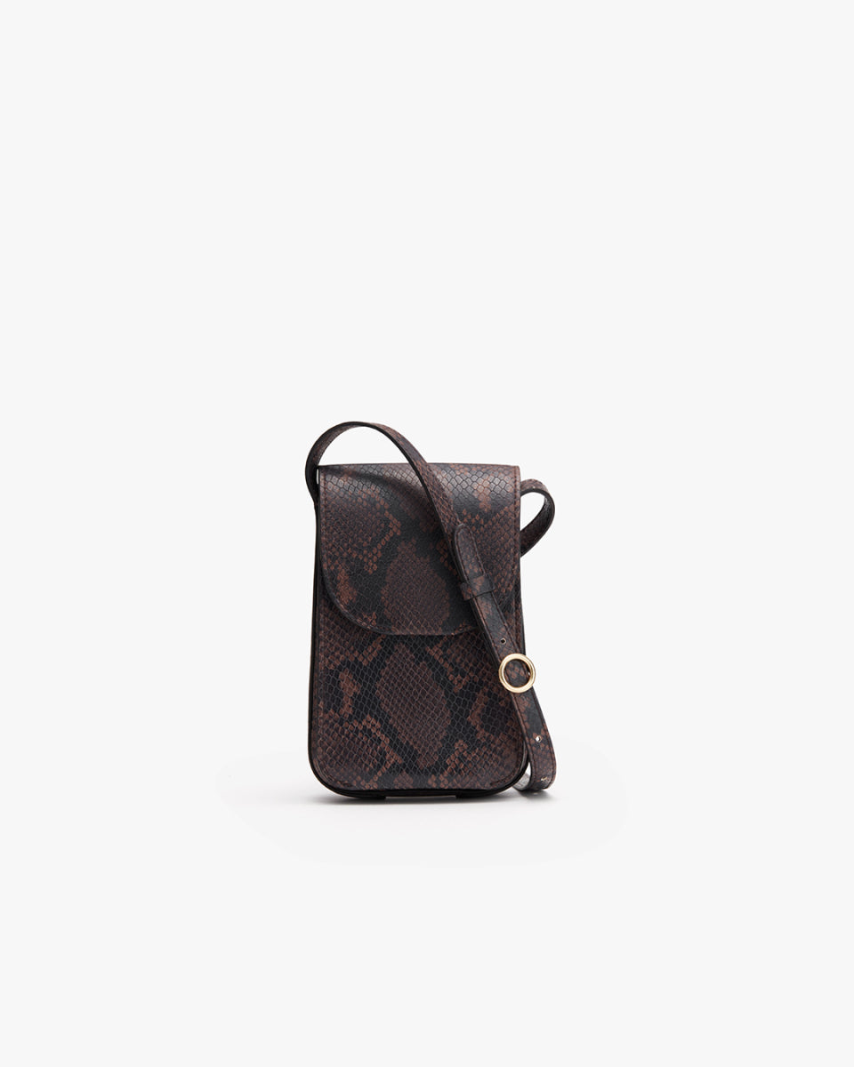 Small patterned crossbody bag with flap closure and adjustable strap.