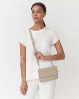 Woman standing with a shoulder bag