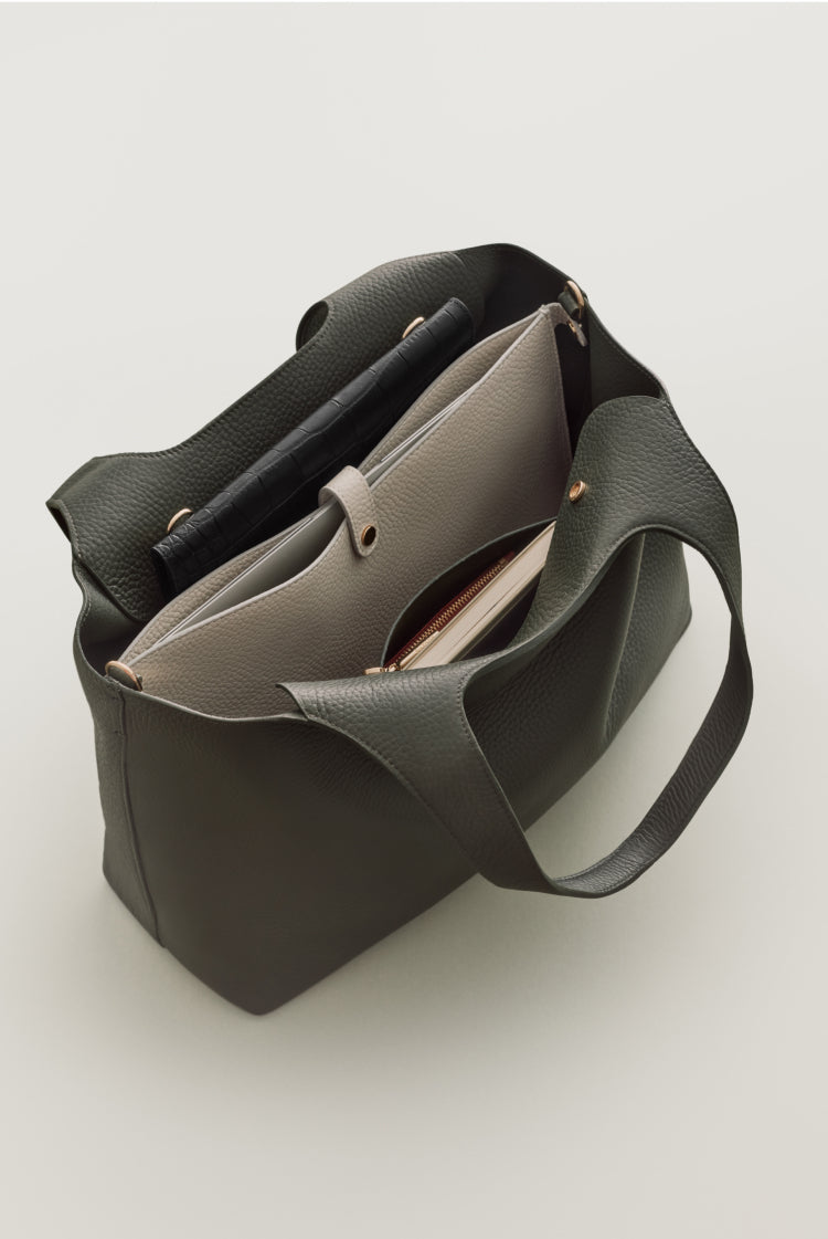 Open handbag with contents partially visible, standing upright