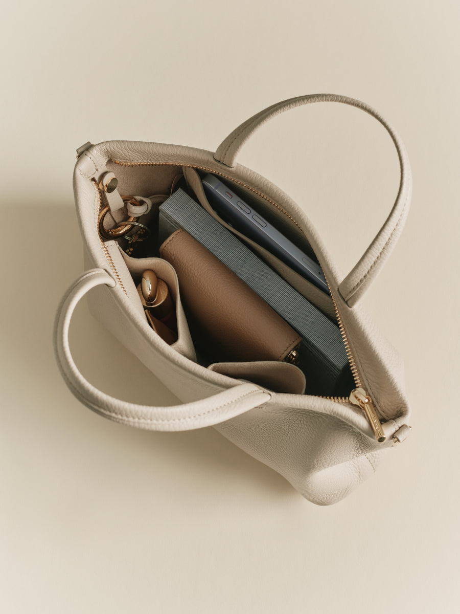 Open handbag with visible contents including a wallet and keys.