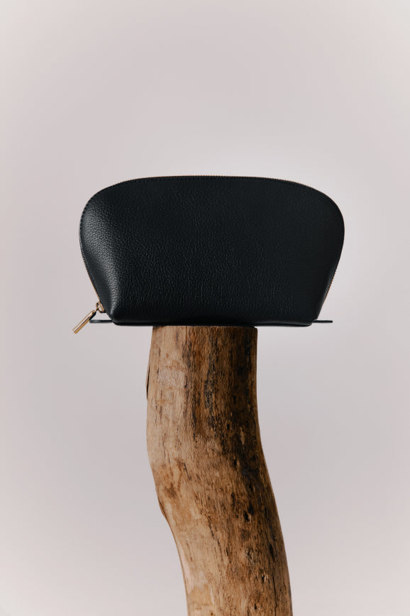 Small pouch on top of a wooden post.