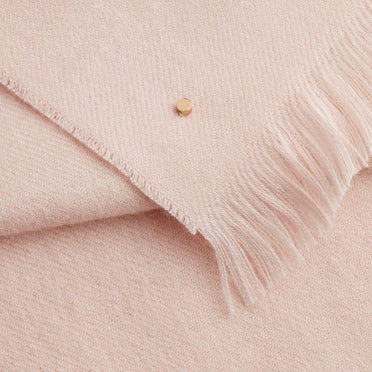 Fabric with fringe and a small button detail.