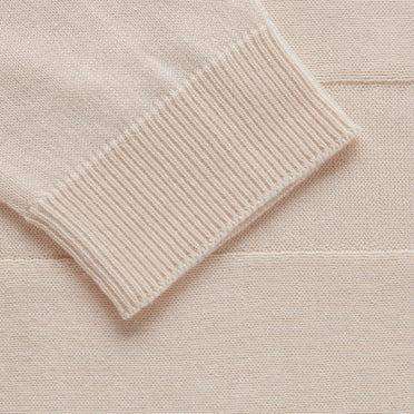 Close-up of a ribbed cuff on fabric with textured background.