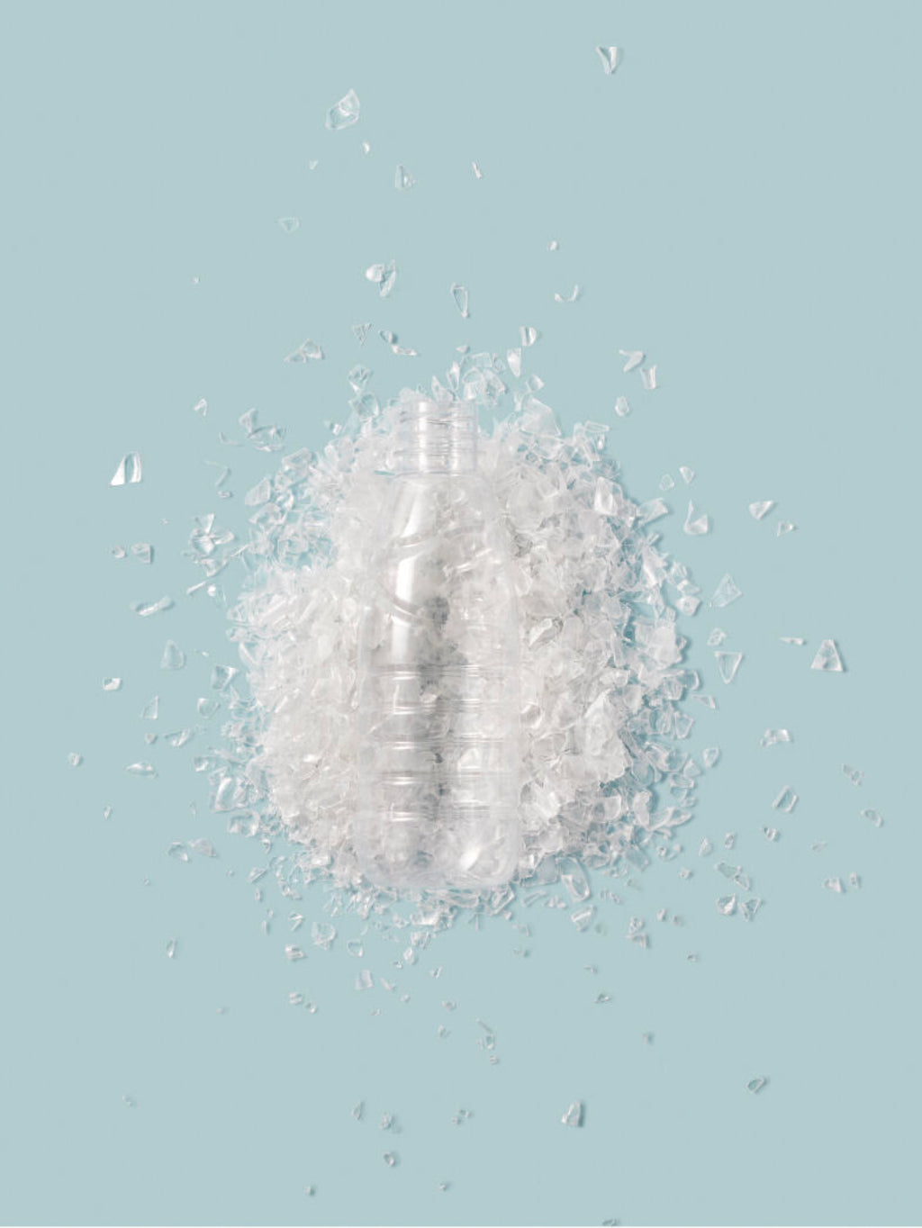 Plastic bottle surrounded by crushed ice on a solid background.
