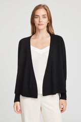 Woman in a cardigan and v-neck top standing straight