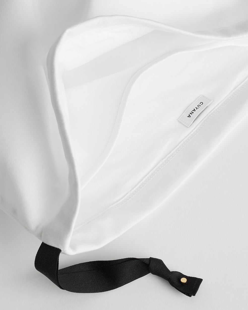 Close-up of a fabric bag with a label and a strap attachment.