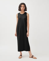 Woman standing in a sleeveless dress and sandals