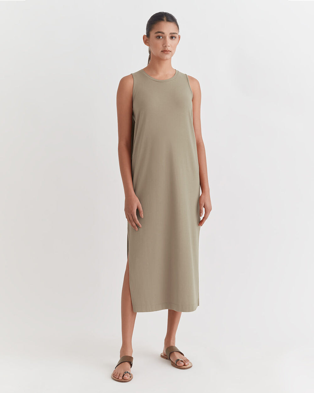Woman standing in a sleeveless dress and sandals