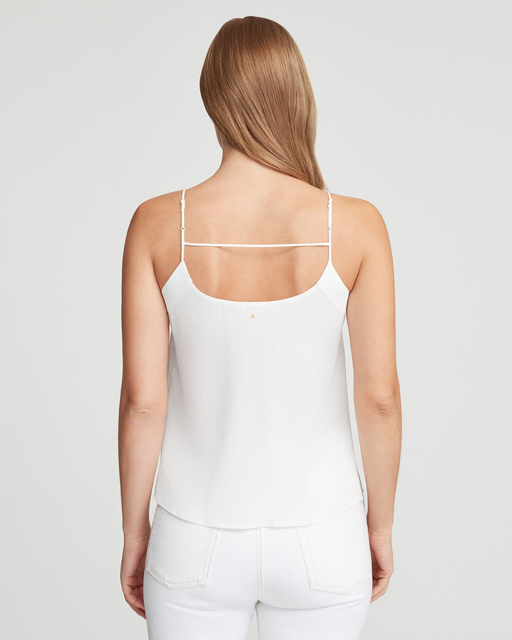 Woman seen from behind wearing a sleeveless top and pants.