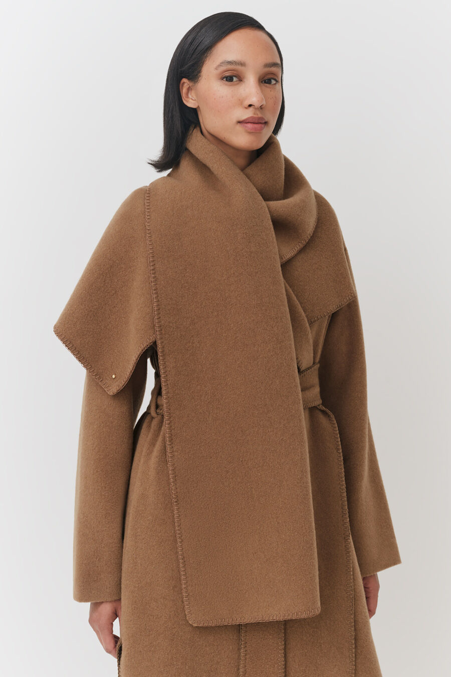Woman wearing a stylish overcoat with a large collar and belt