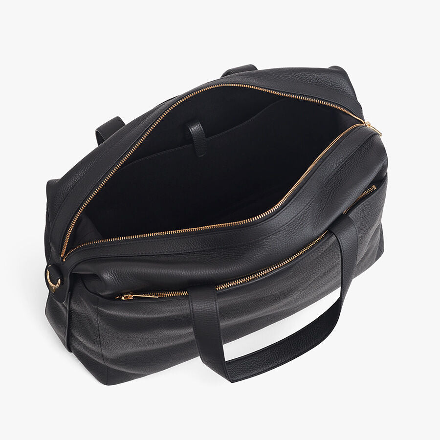 Overhead view of a closed weekender travel bag with handles and zipper closures.